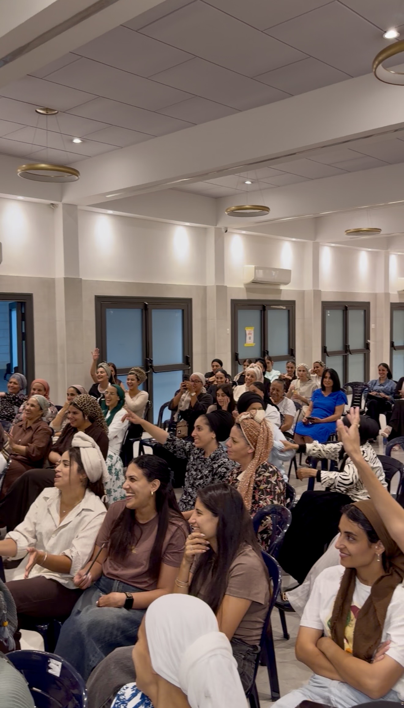 קהל נשים צוחק ונהנה בערב האנרגטי